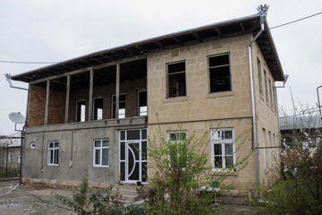 Old village with old gray houses and dry bare trees