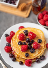 Sweet homemade pancakes with fruits on white plate.
