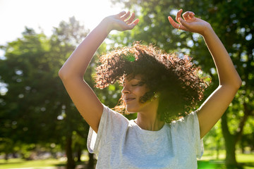 Carefree woman dancing in a park on a sunny afternoon