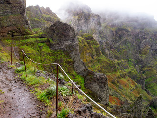 sendero por montañas de colores intensos entre la bruma
