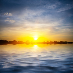 dramaric sunset reflected in a quiet lake, evening outdoor background