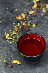 herbal tea scattered on the gray table with bowl red into asian style