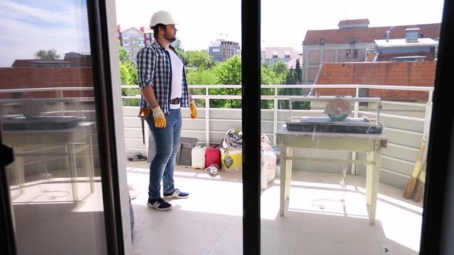 repairman inspecting an apartment with balcony during renovation