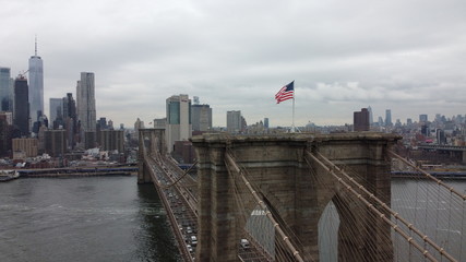 brooklyn bridge and manhattan behind with USA Flag