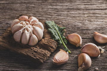 garlic and garlic powder on old wood, close up image