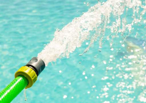 Manguera echando agua. Chorro de agua.