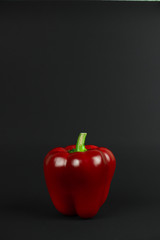 red big bell pepper on a black background