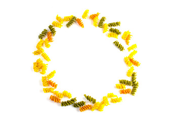 Obraz premium uncooked colored pasta lined around on a white background