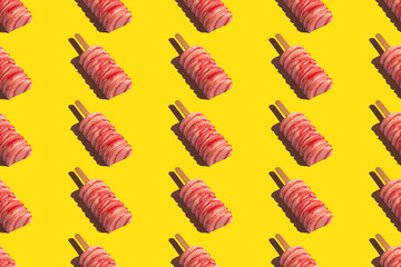 Pink Popsicle with white shavings on a stick. Isolated seamless pattern on a solid yellow background