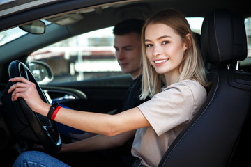 Fototapeta na wymiar Driving instructor and woman student in examination car.