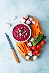 Beet hummus appetizer with carrot, radish, tomato and cucumber