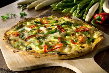 Homemade pizza with asparagus, red pepper, hollandaise sauce, mozzarella and fresh oregano