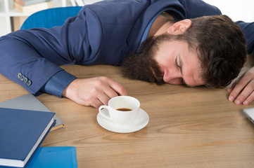 Does not help. Man handsome boss sleep in office drinking coffee. Comfy workspace. Hard morning. Bearded hipster formal suit relaxing with coffee. Office life routines. First coffee. Sleepless night