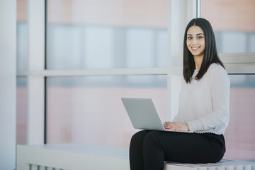 Elegant HR employee working on a laptop waiting for an internship candidate