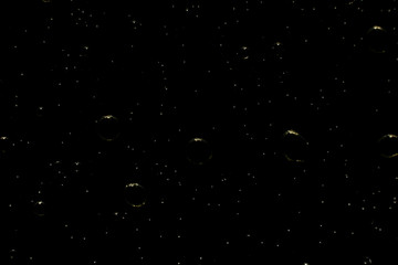 Viele kleine Olivenöltropfen auf einem schwarzen Hintergrund.