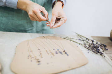 The potter's hands are shaped a cup from a clay. The process of creating pottery. The master ceramist works in his studio. Close-up, only hands. Crockery from clay own hands.	