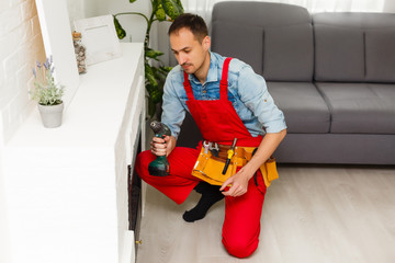 Fototapeta na wymiar repairman repairs and installs a fireplace in the apartment