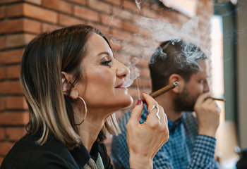Close-up of a woman in a restaurant enjoying tobacco smoke