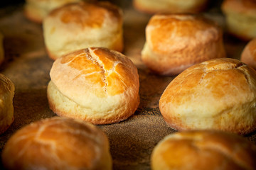 Closeup of freshly prepared english scone on tray with powder with various buns 
