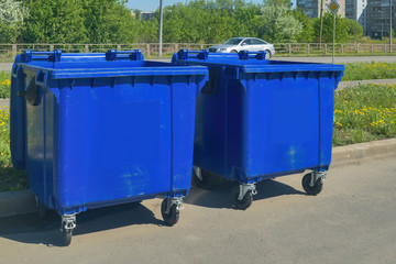 Two plastic trash recycling containers. Blue containers for collecting garbage on the dustbin.