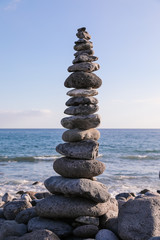 The pyramid built of stones of different sizes and keeps the balance. The pyramid stands near the sea