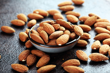 Almonds on a rustic background and almond in bowl.