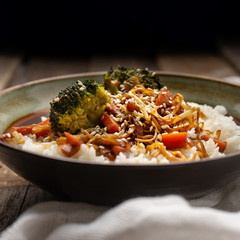 Thai style rice with fried vegetables and soy sauce on wooden background