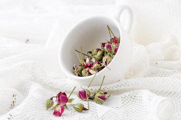 Flower tea rose buds on old wooden table