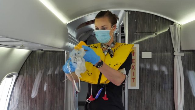 Oxygen Mask Safety Demo Prior Departure by Stewardess with Mouth Mask.