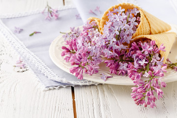 Fototapeta na wymiar View purple lilacs. Shallow depth of field with lilacs and lilac leaves on wooden table