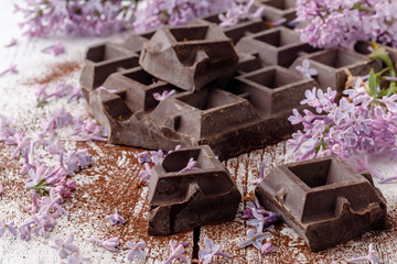 Dark chocolate on table with liliac flowers