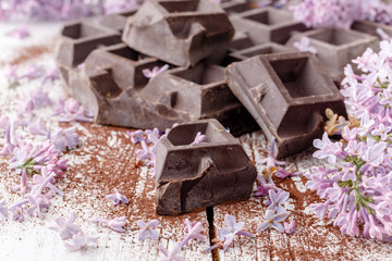 Dark chocolate on table with liliac flowers