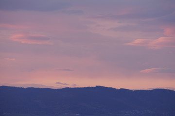Beautiful colorful sky after sunset over mountains.