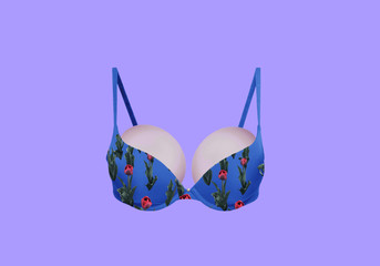 Sexy bra in blue on an isolated background. Bra in colors. Peonies on a pattern of clothes. Breast disease. Demonstration of the properties of elasticity, softness, strength, reliability implant