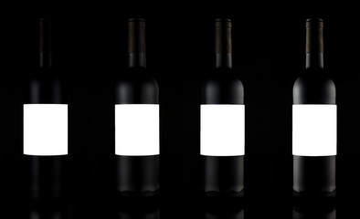 Four bottles of wine with empty labels for text and logo Studio shots