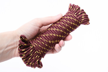 A coil of nylon rope, cord, paracord in a hand isolated on white background