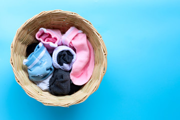 Laundry basket with socks on blue background.
