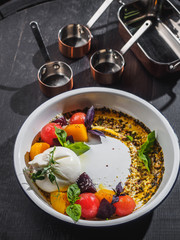 Salad with mozzarella and cherry in the enamel plate