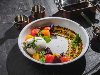 Salad with mozzarella and cherry in the enamel plate