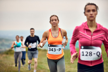Fototapeta na wymiar Young athletic woman running marathon in nature.
