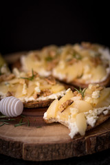 Pear and blue cheese toast with rosemary and honey on a dark and rustic background