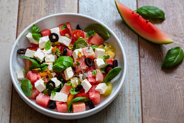 Summer salad with watermelon, tomatoes, feta cheese and basil