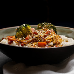 Thai style rice with fried vegetables and soy sauce on dark background