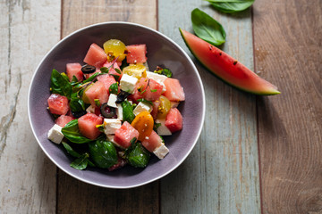 Summer salad with watermelon, tomatoes, feta cheese and basil