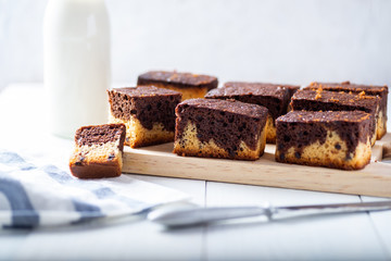 freshly baked brownie on a rustic white wooden background and with some breakfast ingredients