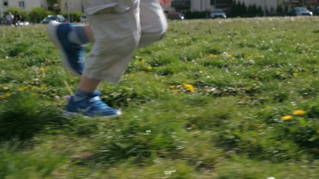 Kid running on field. Active boy on nature. Slow motion