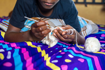 african teenage boy loves knitting at home