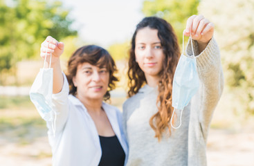 Mother and daughter take off their gang protection mask. End of coronavirus. Family celebrating the end of the coronavirus. Dropping the mask for the end of the pandemic. Social distance. Coronavirus