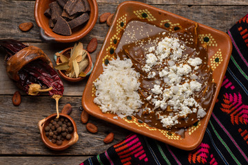 Mexican mole enchiladas with rice on wooden background