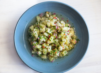 Pineapple ceviche on a white surface and blue dish